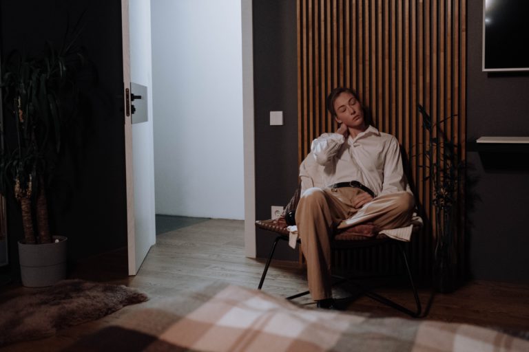 Zmęczona kobieta siedząca na krześle w pokoju